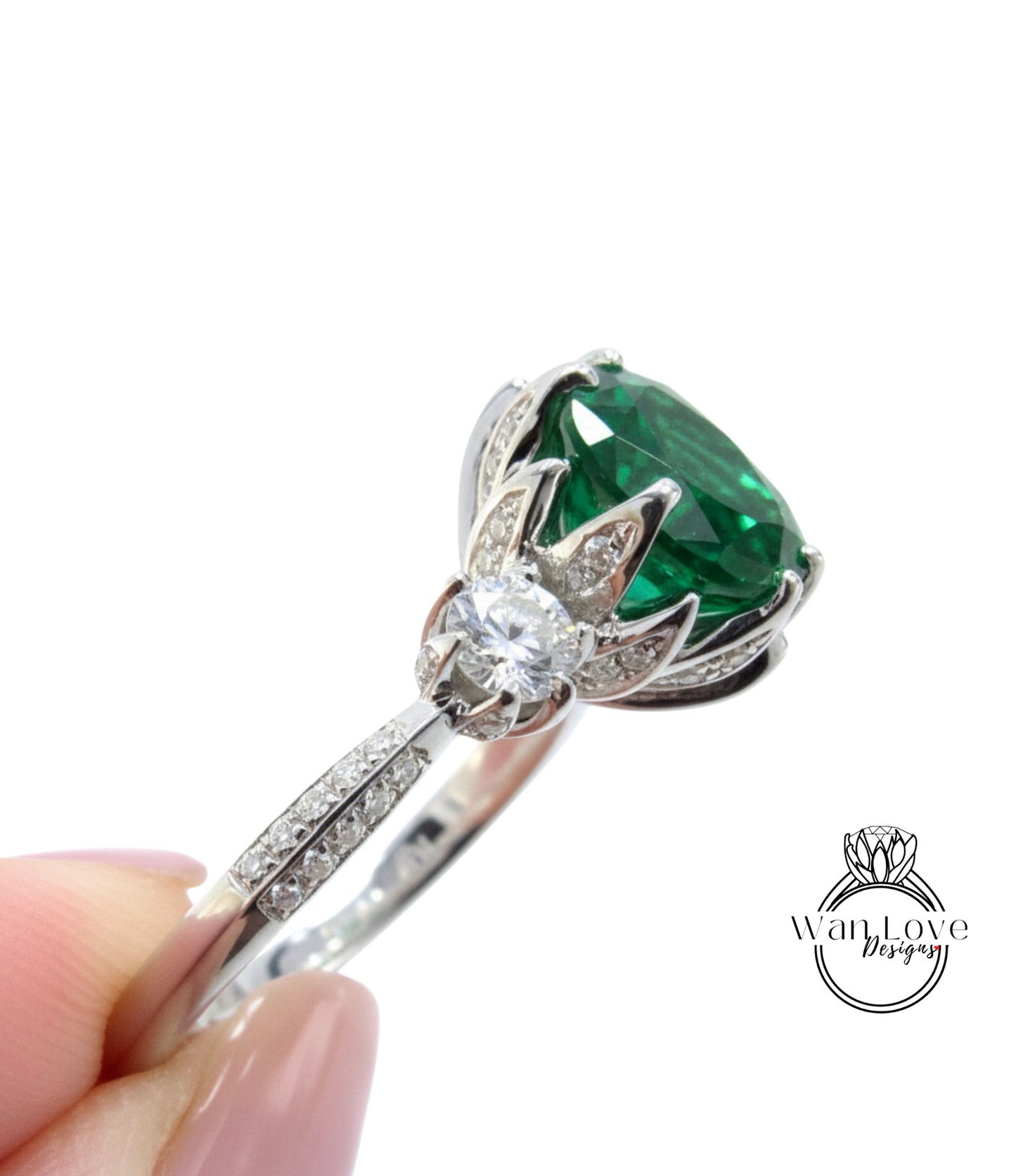 A close-up of a silver ring with a large green gemstone, possibly a diamond, set in a decorative design.