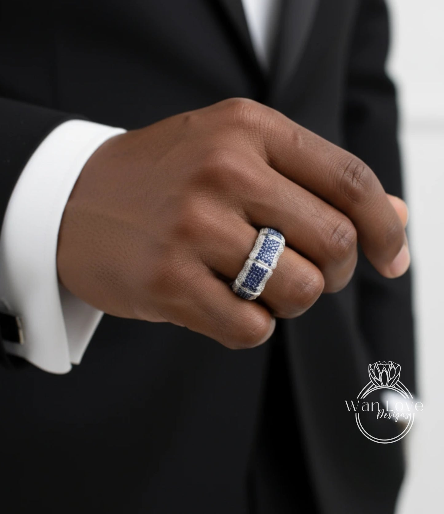 A close-up of a person's hand wearing a ring with a blue and white gemstone.