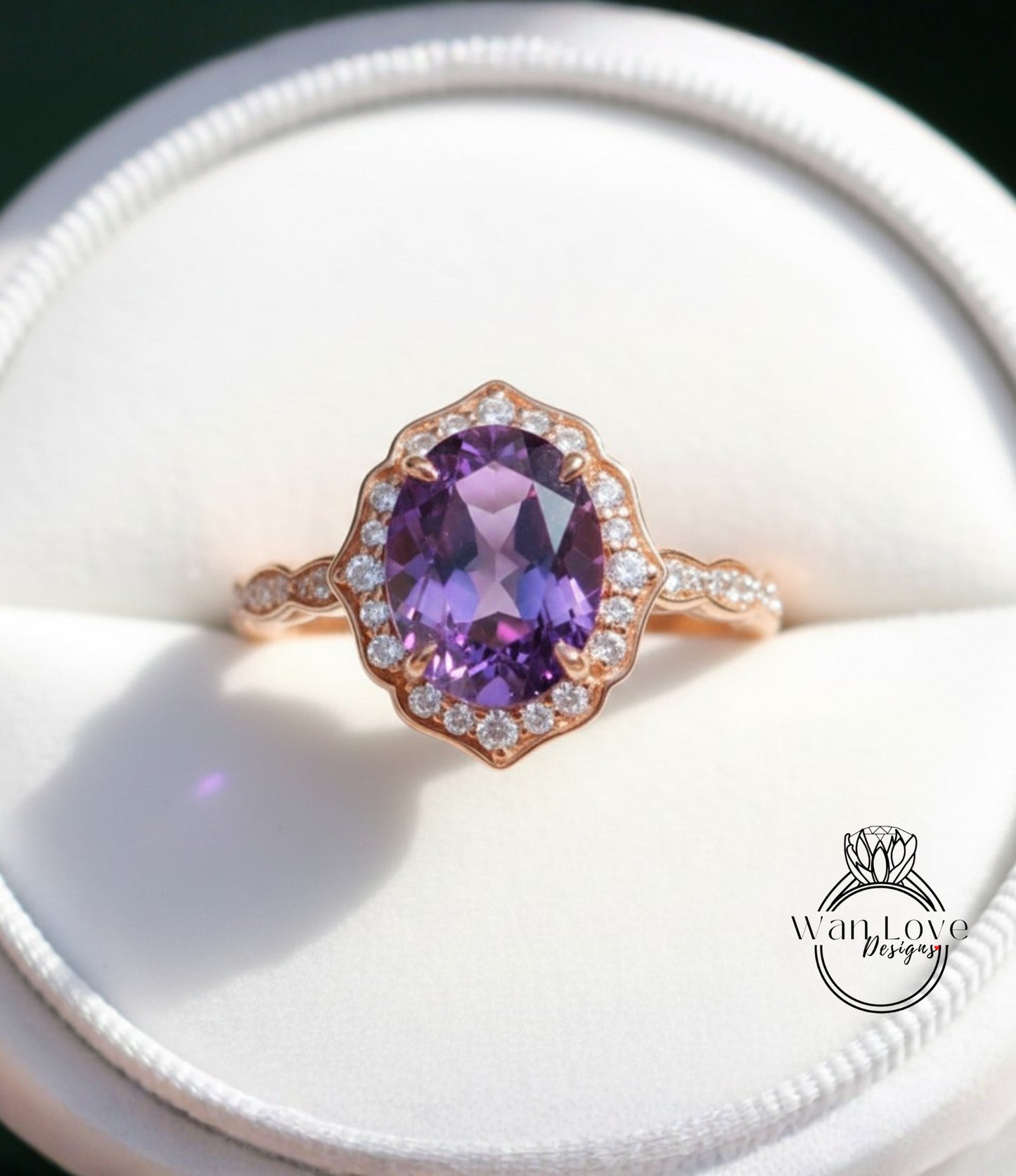 A close-up image of a gold ring with a large oval-shaped purple gemstone, surrounded by smaller diamonds, placed in a white jewelry box.