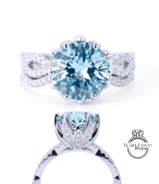 A stunning blue gemstone ring with a large central stone surrounded by smaller stones, set in a silver band with a delicate flower-like design.