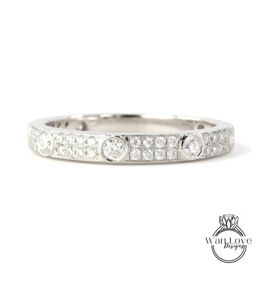 A silver band ring with a row of small diamonds set in the center.