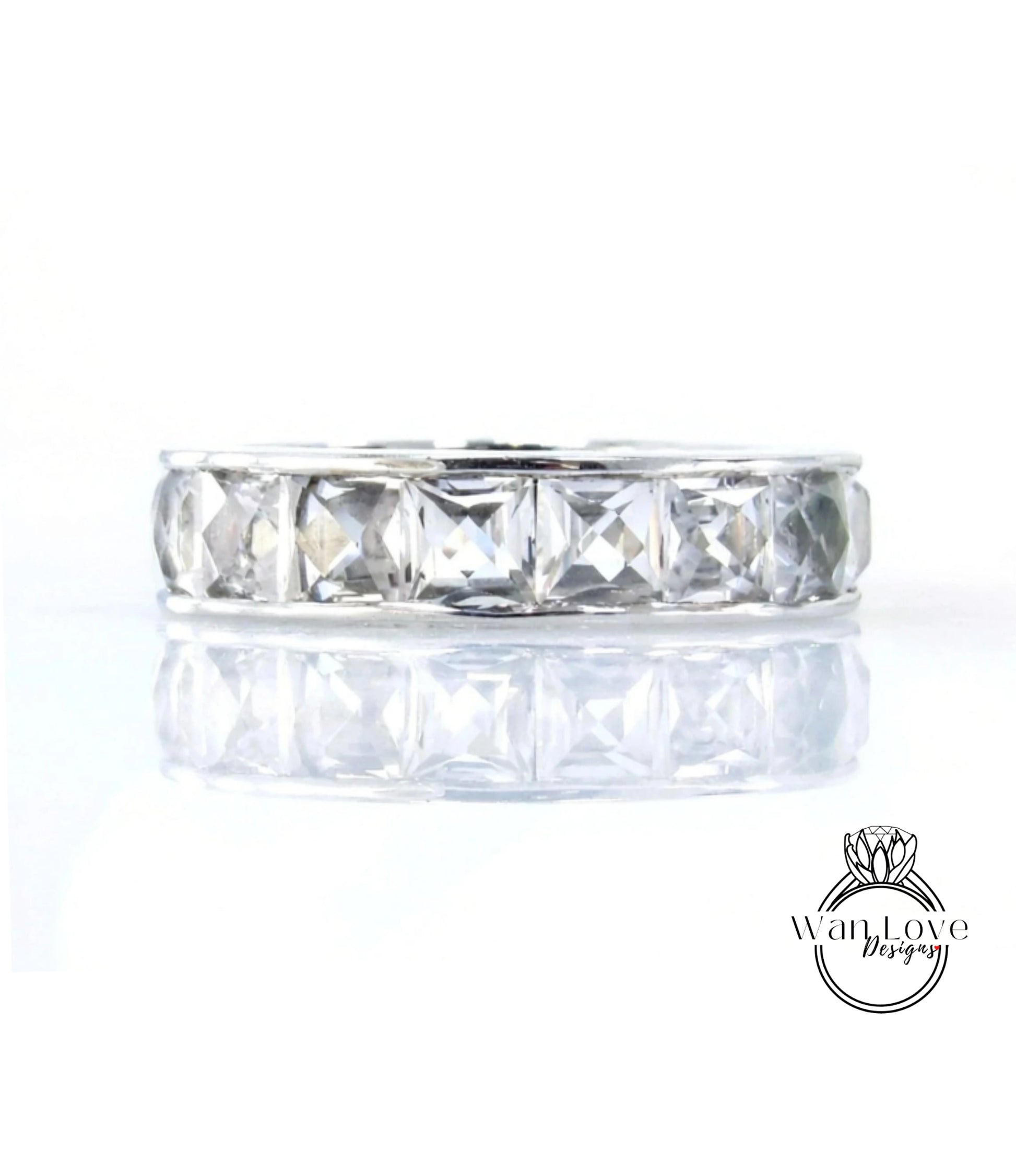 A silver band with a row of clear gemstones, likely diamonds, set in a ring design.
