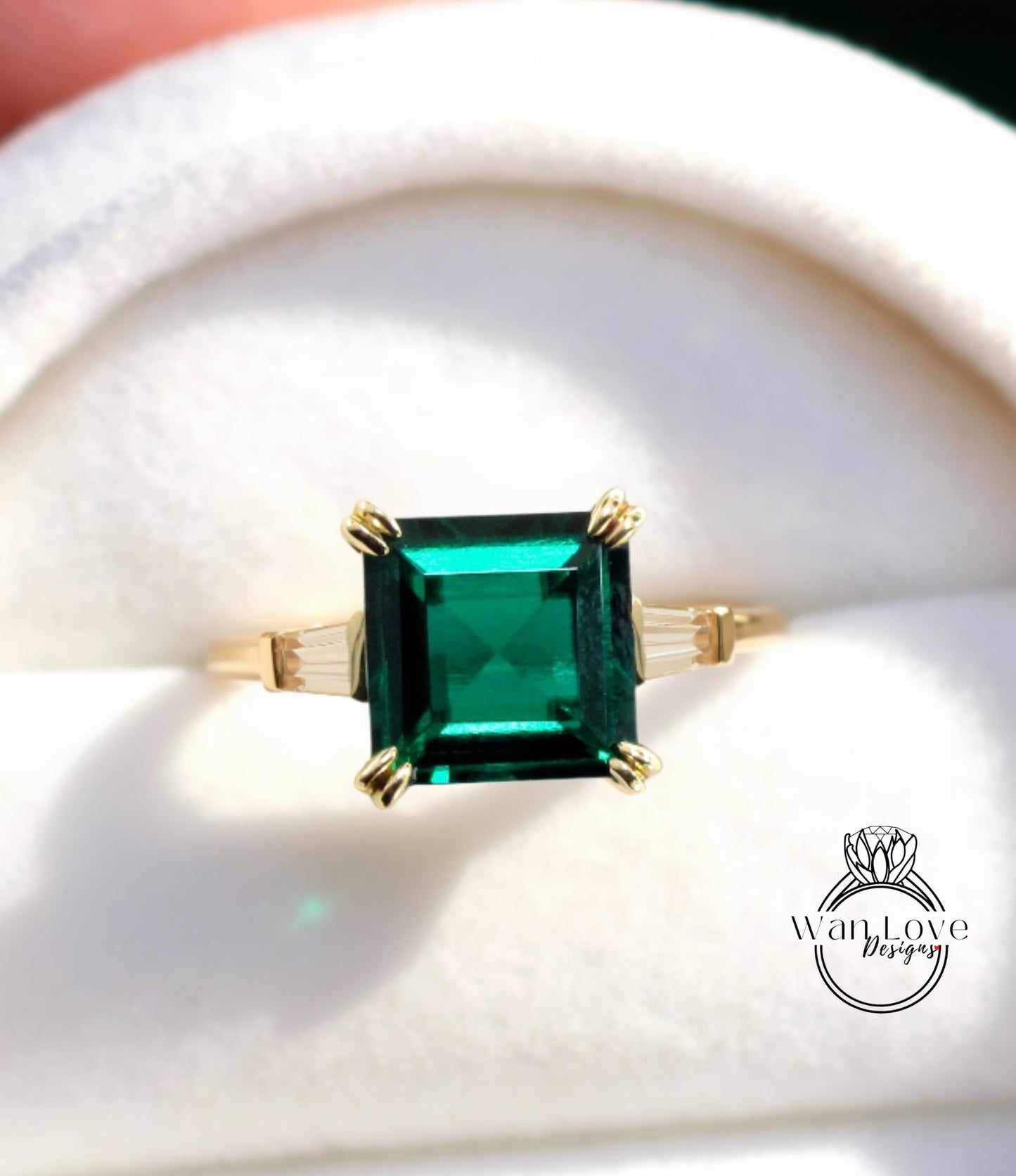 A gold ring with a large, square-shaped green gemstone set in the center.