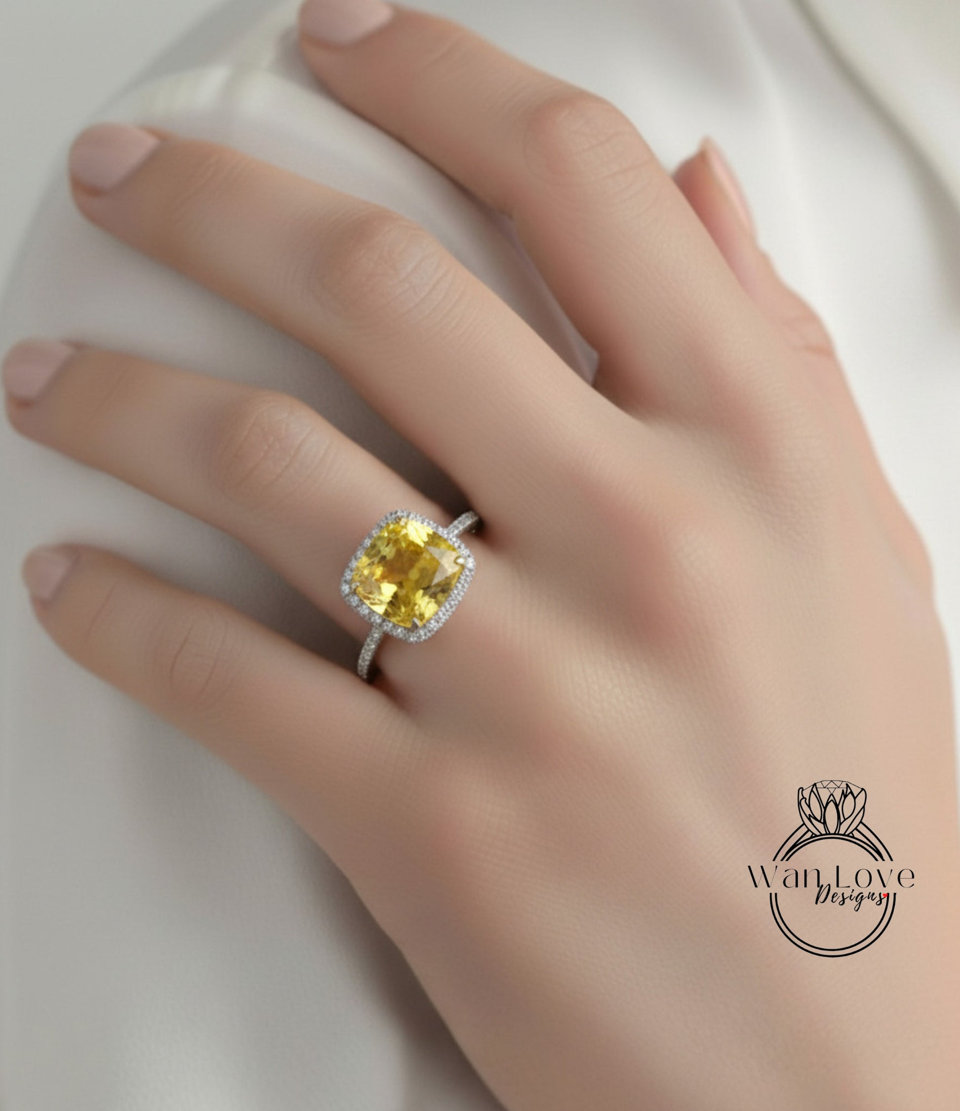A close-up of a hand wearing a yellow gemstone ring with a halo of diamonds around it.