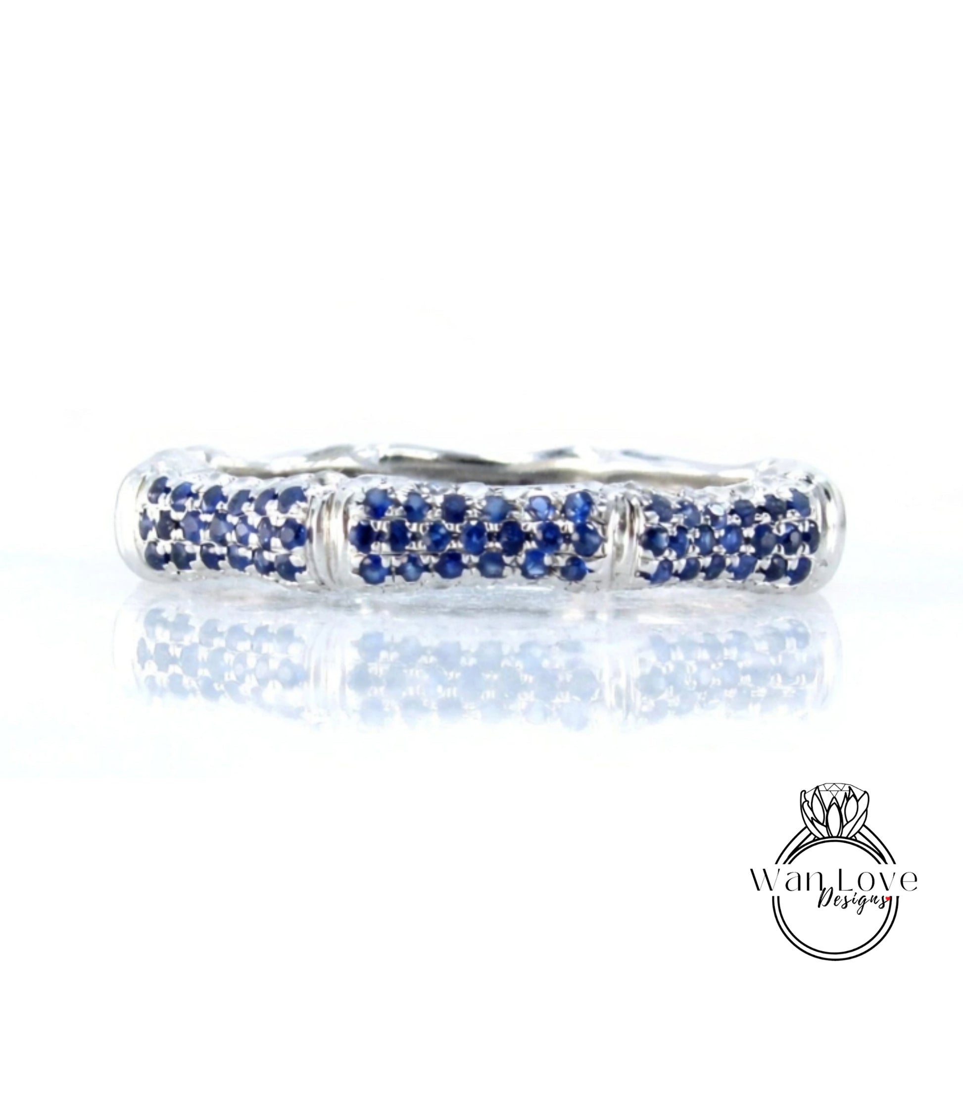 A silver ring with blue sapphires set in a decorative pattern.