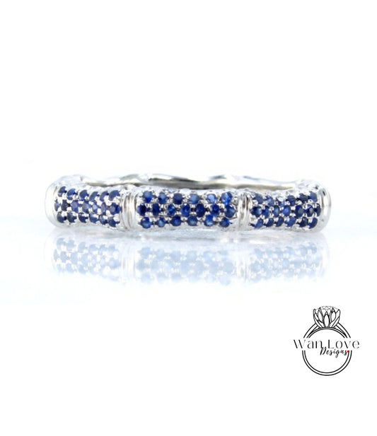 A silver ring with blue sapphires set in a decorative pattern.