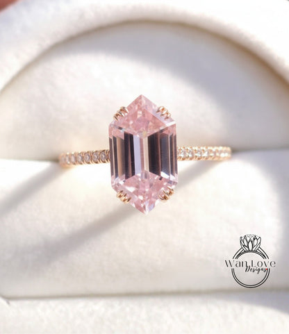 A close-up image of a gold ring with a large, pink gemstone set in the center.