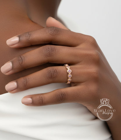 A close-up of a person's hand wearing a gold ring with a row of small, round stones.