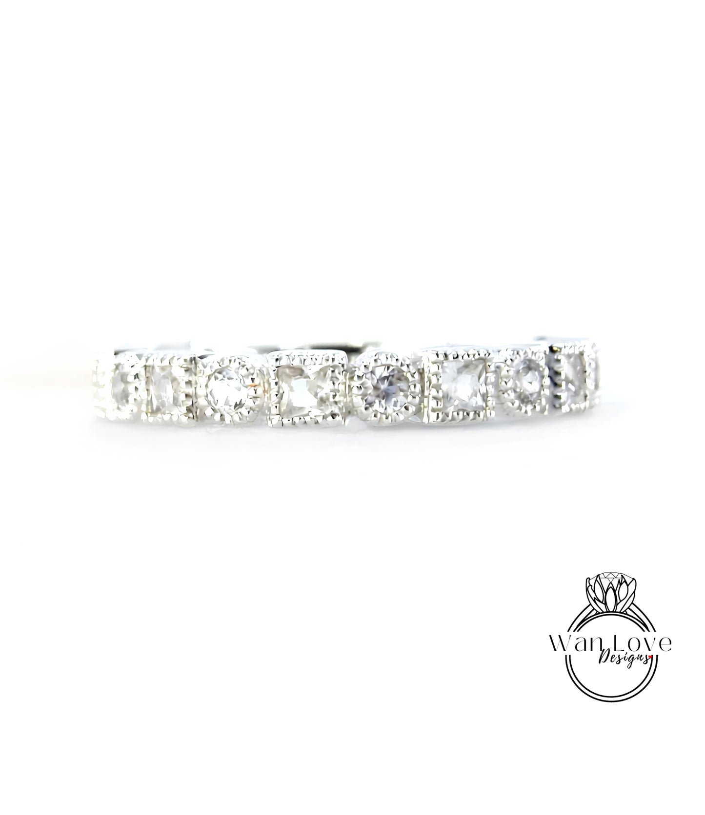 A silver band with a row of clear gemstones, likely diamonds, set in a decorative pattern.