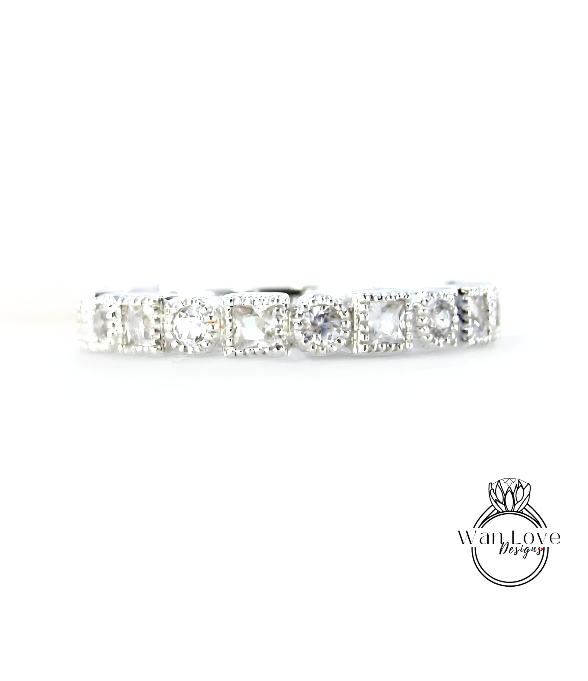 A silver band with a row of clear gemstones, likely diamonds, set in a decorative pattern.
