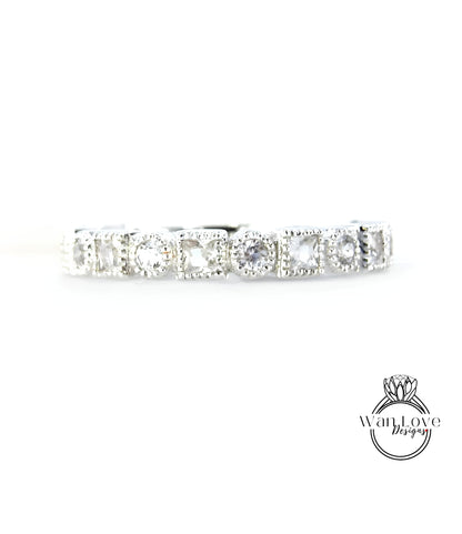 A silver band with a row of clear gemstones, likely diamonds, set in a decorative pattern.