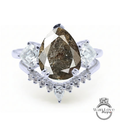 A close-up of a diamond engagement ring with a large pear-shaped diamond at the center, surrounded by smaller diamonds.