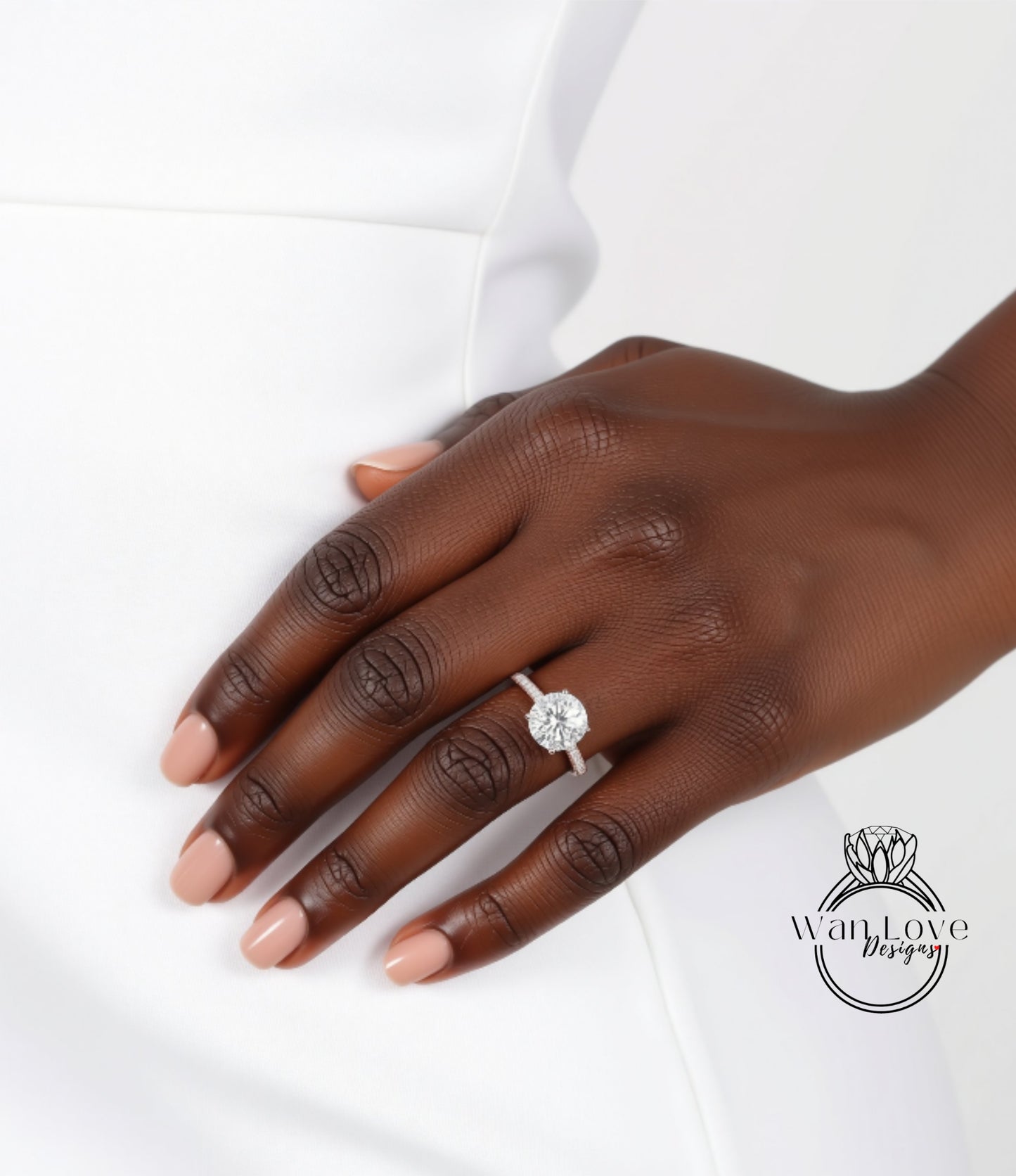 A close-up of a hand wearing a diamond engagement ring.