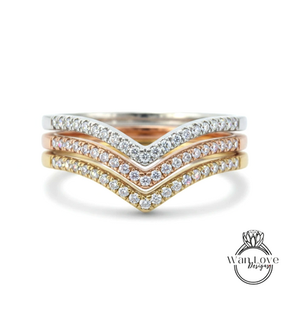 A ring with a diamond band featuring three different colored diamonds arranged in a v-shape.