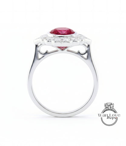 A silver ring with a large red gemstone, likely a ruby, set in a halo of smaller diamonds.