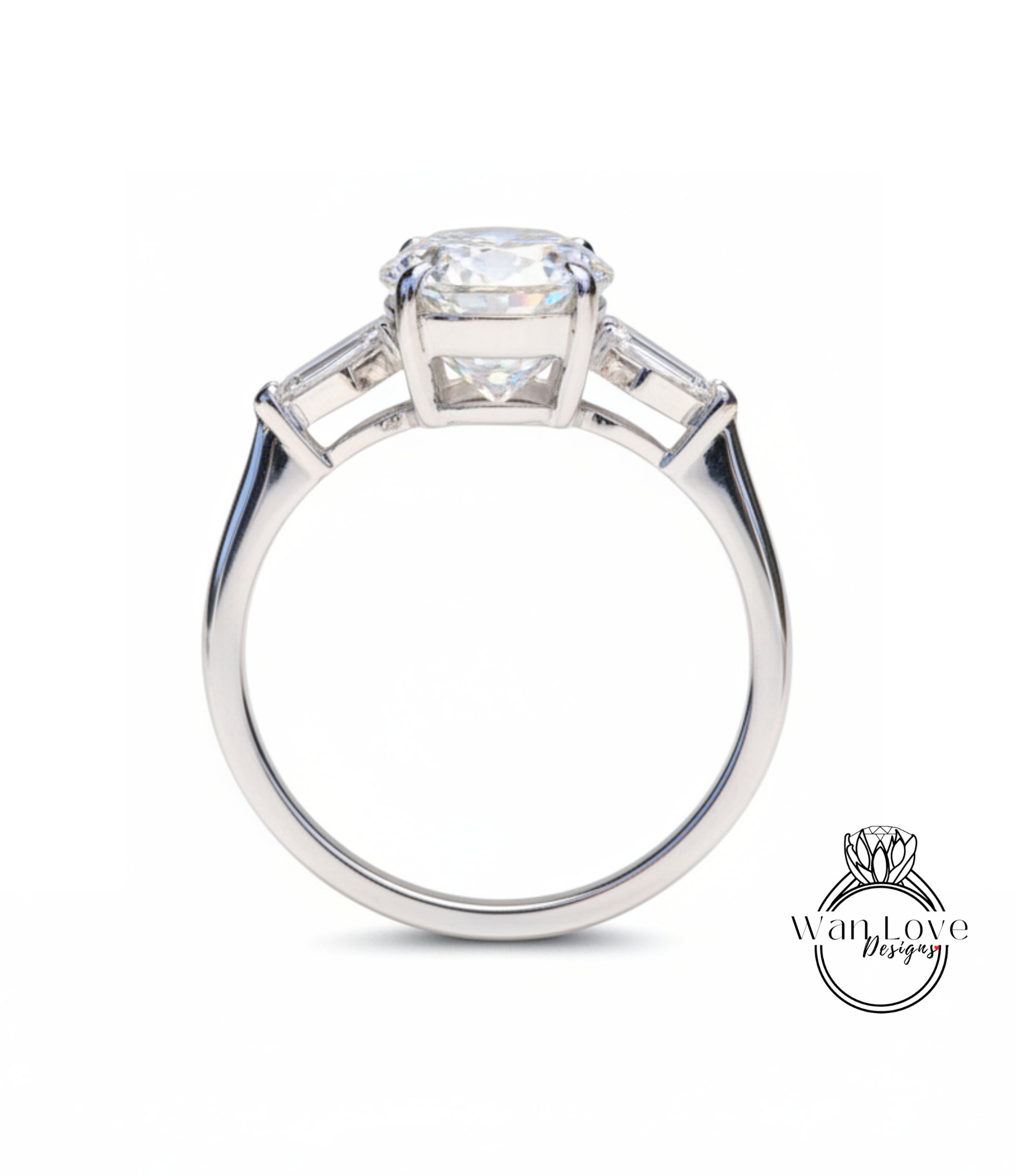 A close-up of a silver engagement ring with a large central diamond and two smaller diamonds on either side.