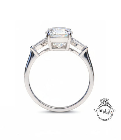 A close-up of a silver engagement ring with a large central diamond and two smaller diamonds on either side.