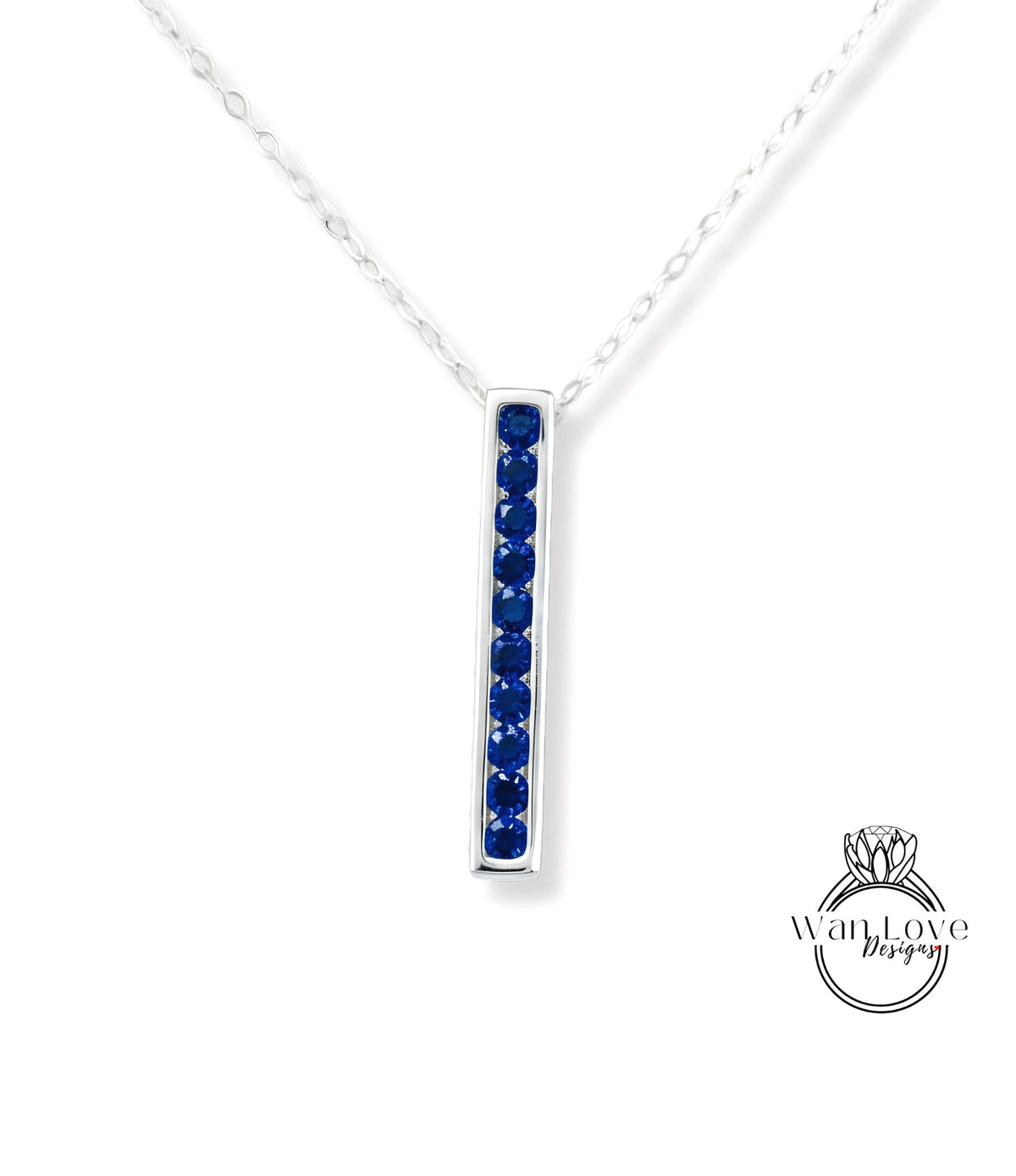 A silver necklace with a vertical row of blue gemstones, likely sapphires, set in a rectangular pendant.
