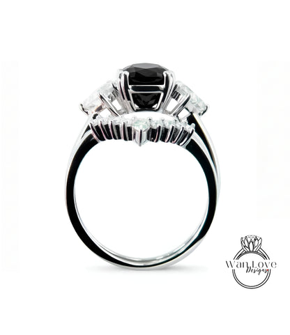 A silver ring with a large black gemstone, possibly a diamond, surrounded by smaller gemstones.