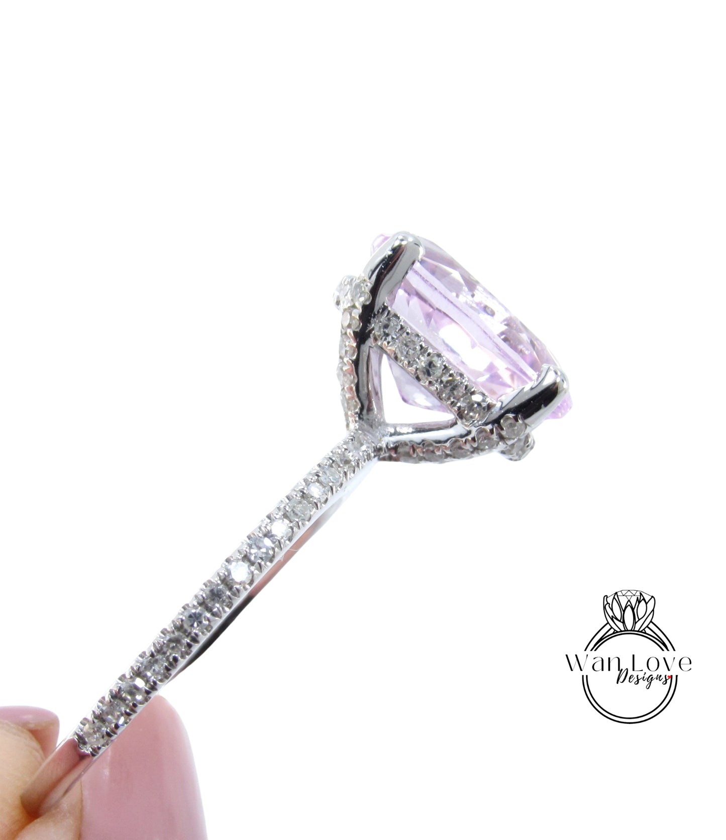 A close-up view of a large, pink gemstone set in a silver ring with a diamond-encrusted band.