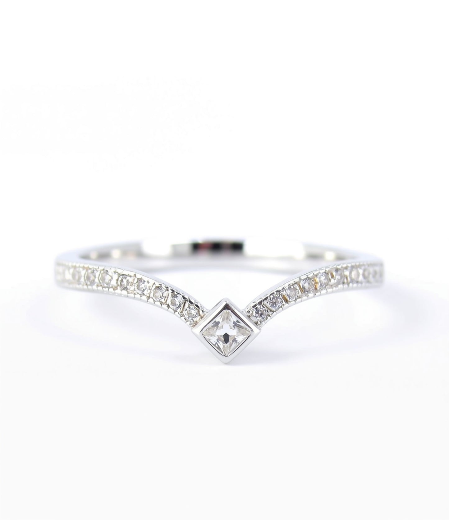 A silver ring with a diamond-encrusted band and a central square-shaped diamond.