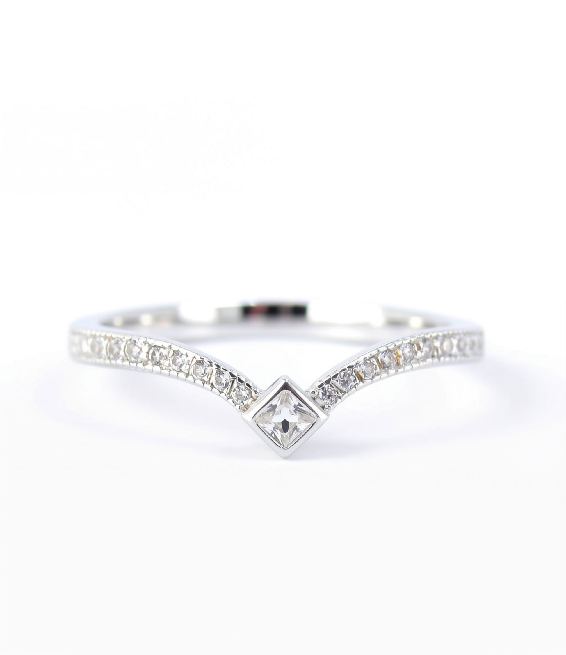A silver ring with a diamond-encrusted band and a central square-shaped diamond.