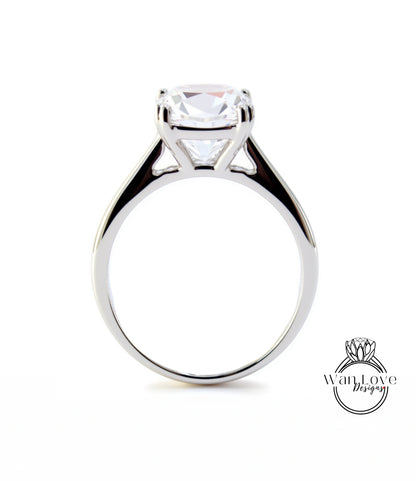 A silver engagement ring with a large, clear gemstone set in the center of the band.