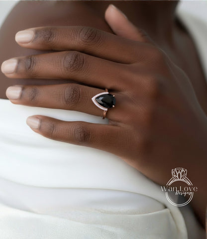 A close-up of a person's hand wearing a ring with a large black gemstone.