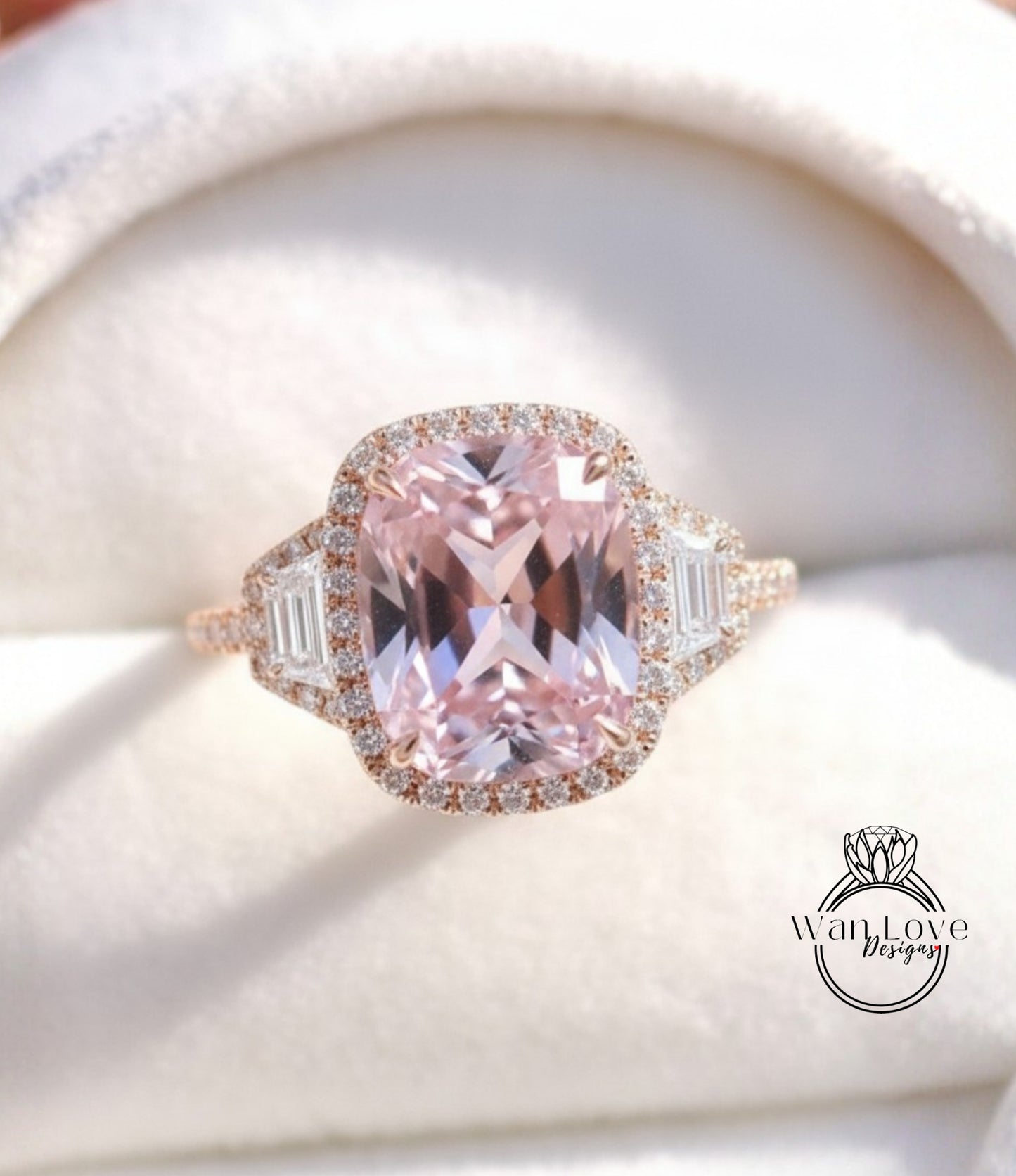 A close-up image of a beautiful pink gemstone ring with a halo of smaller diamonds around it, displayed on a white background.