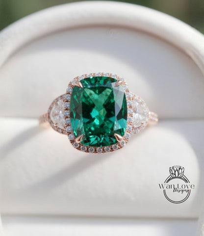A close-up image of a large, green gemstone ring with a halo of smaller diamonds around it, displayed on a white background.