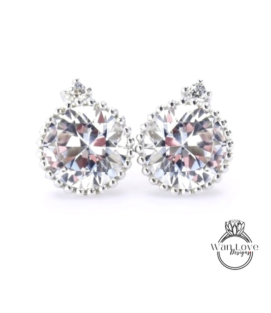 A pair of elegant earrings with large, sparkling diamonds set in a delicate, round frame.
