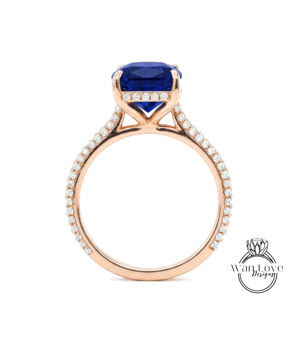 A gold ring with a large blue gemstone, likely a sapphire, set in the center. The ring has a delicate band adorned with small diamonds.