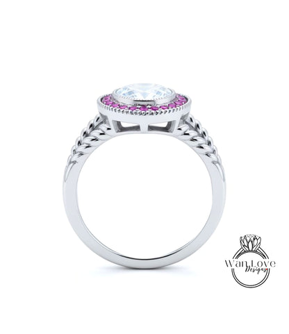 A silver ring with a large central gemstone surrounded by smaller stones, and a decorative band with braided elements.