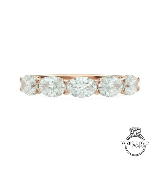 a beautiful rose gold ring with a row of five oval-shaped diamonds set in the band.