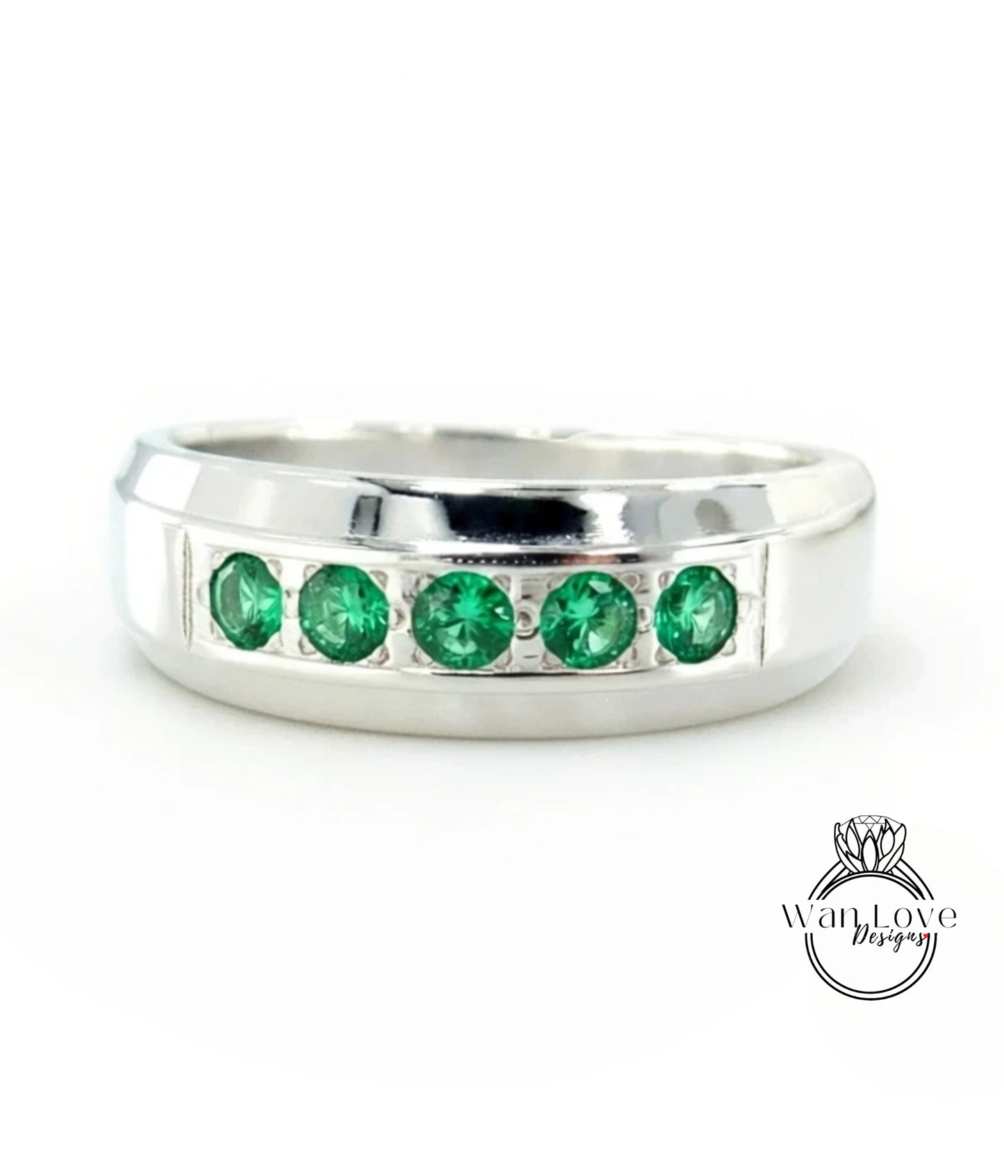 A silver ring with a row of green gemstones set in the band.