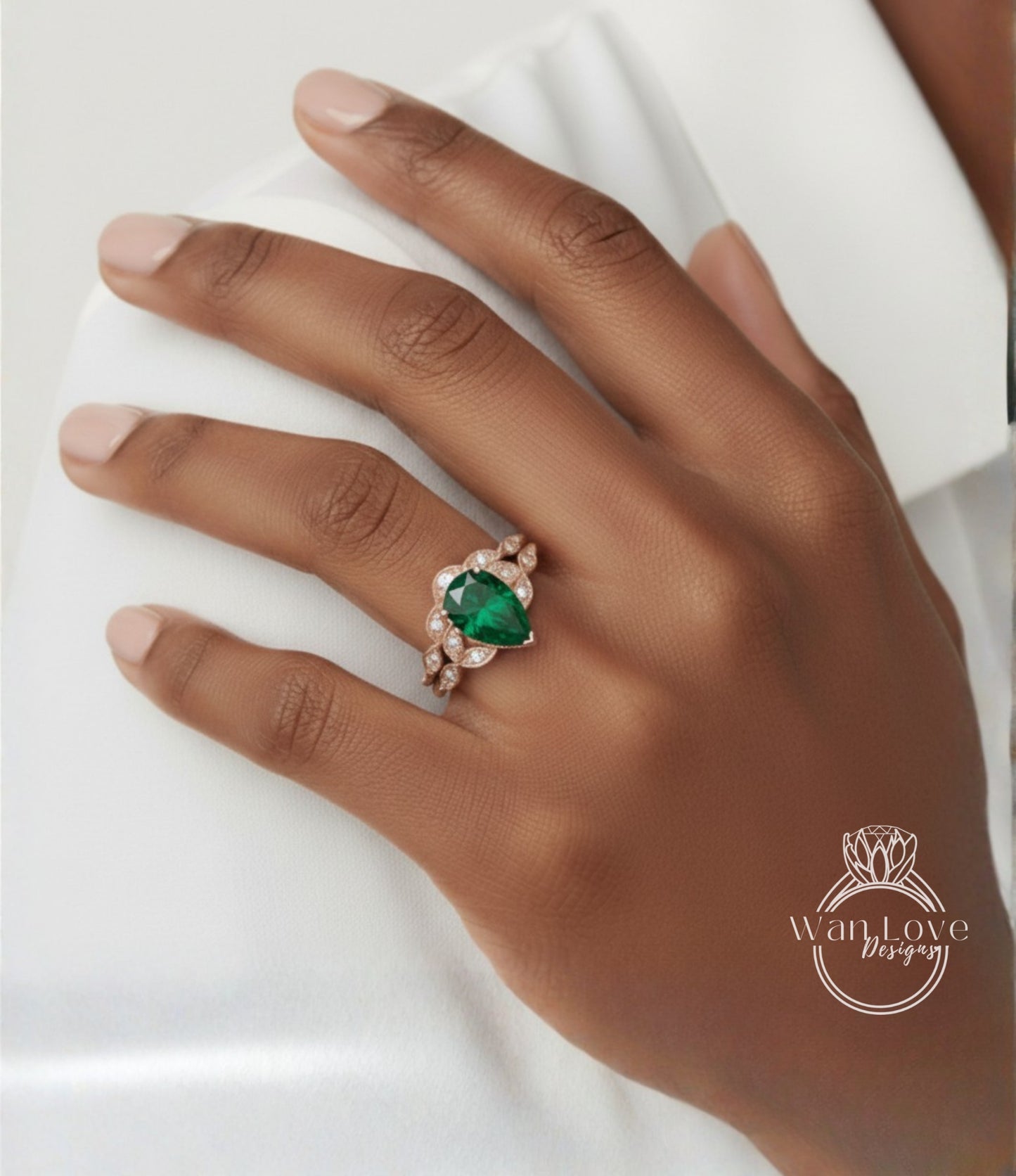 A close-up of a hand wearing a ring with a large green gemstone.