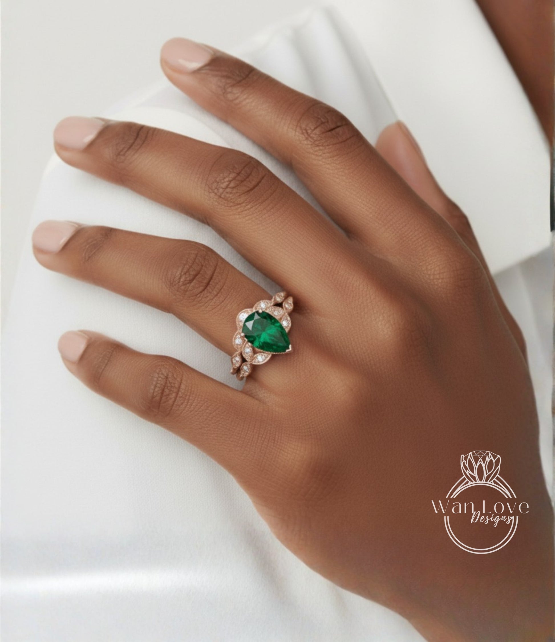 A close-up of a hand wearing a ring with a large green gemstone.