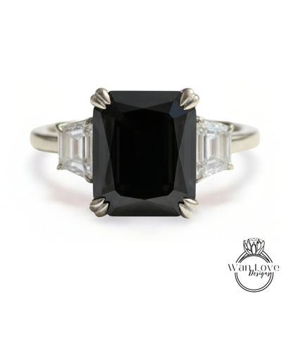 A silver ring with a large black diamond as the centerpiece, surrounded by smaller diamonds.