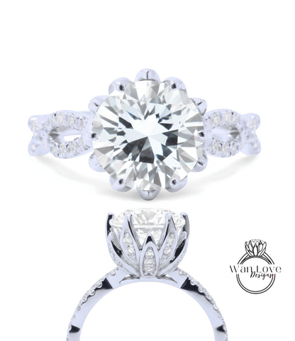 A stunning diamond engagement ring with a large round brilliant cut diamond set in a halo of smaller diamonds, surrounded by a delicate floral design.