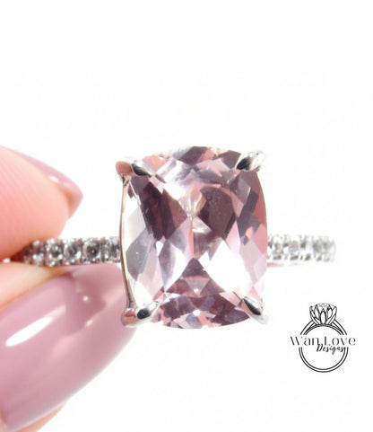 A close-up of a person's hand holding a ring with a large, clear gemstone, likely a diamond, set in a silver band.