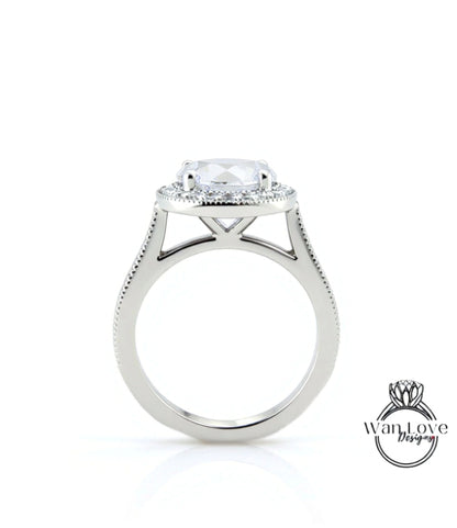 A silver engagement ring with a large central diamond and a halo of smaller diamonds around it.