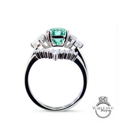 A silver ring with a large green gemstone, possibly a diamond, set in the center.