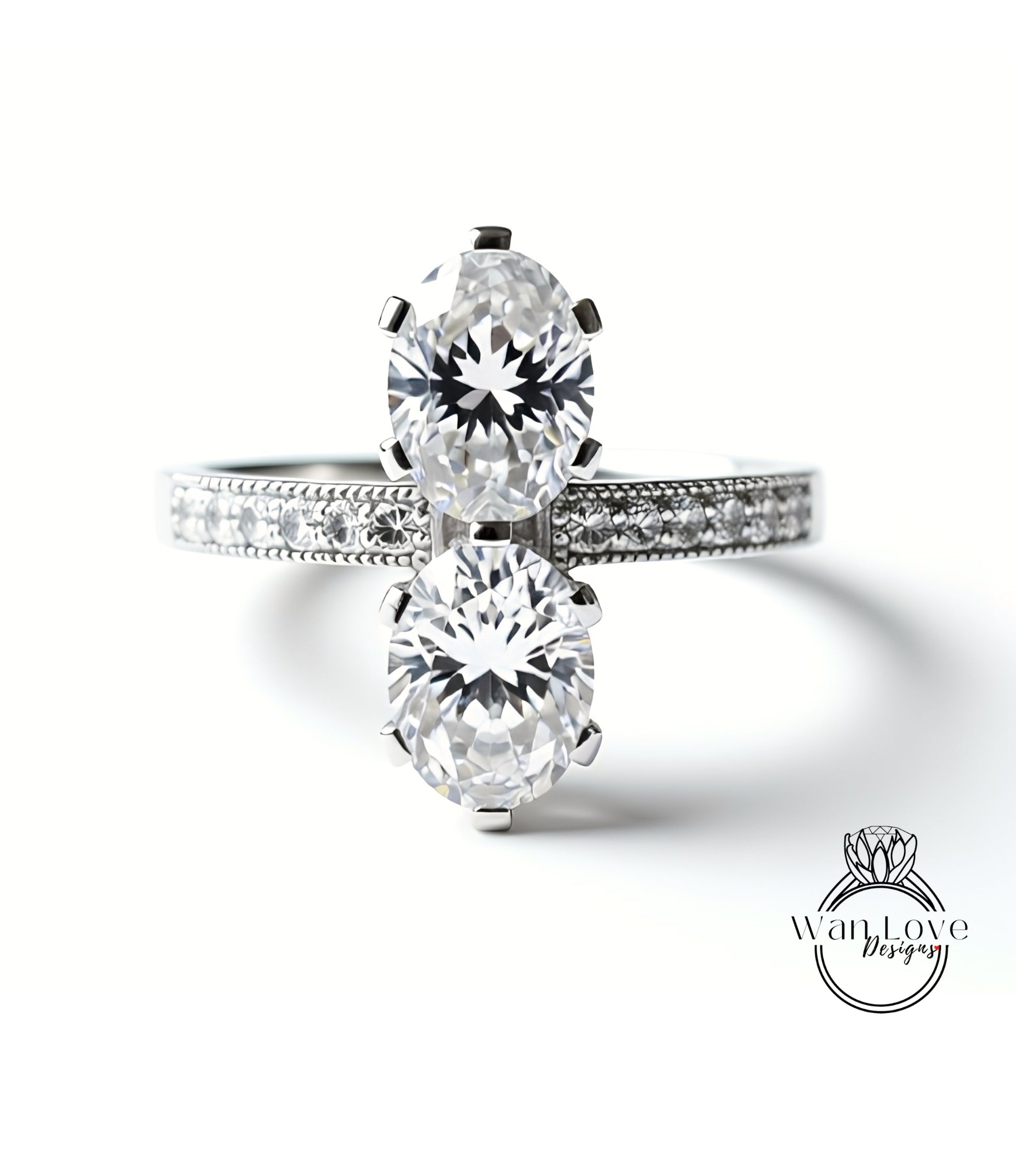 A close-up of a diamond engagement ring with two large, round diamonds set in a silver band.