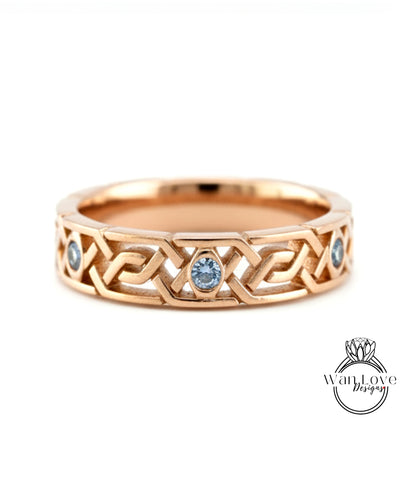 A gold ring with a Celtic knot design and two blue gemstones.