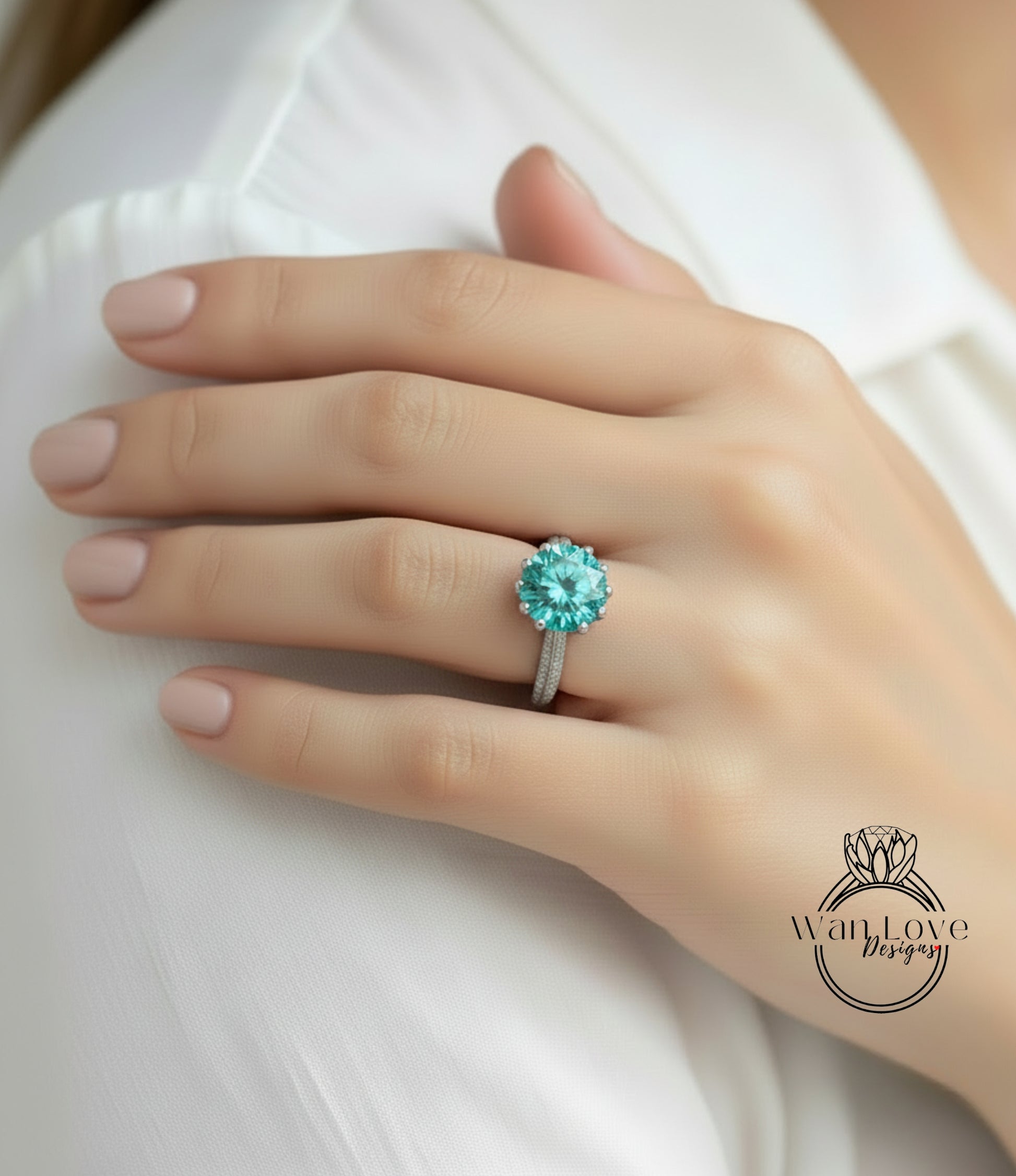 A close-up of a person's hand wearing a large, turquoise-colored diamond ring on the ring finger.