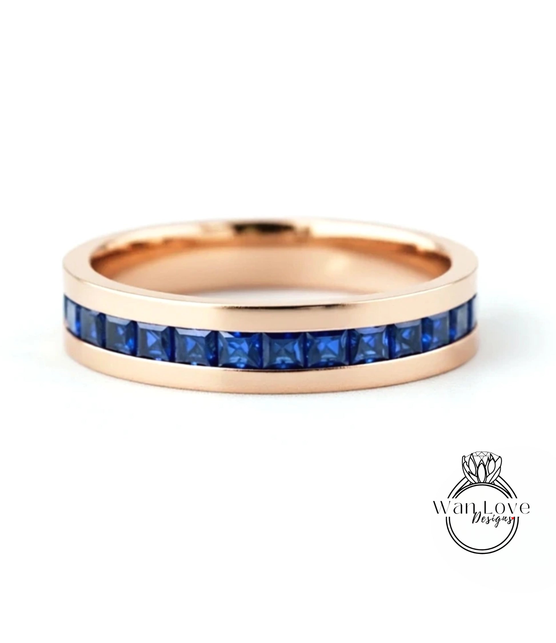 A gold-colored ring with a row of blue gemstones, likely sapphires, set in the band.