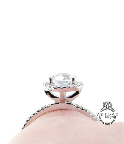 A close-up view of a diamond engagement ring with a large central diamond surrounded by smaller diamonds on the halo.