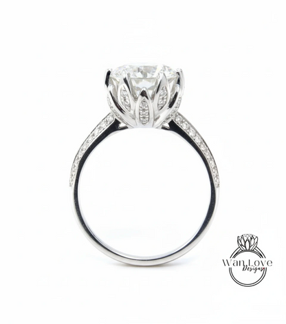 A silver engagement ring with a large, round diamond set in a flower-like design, surrounded by smaller diamonds.