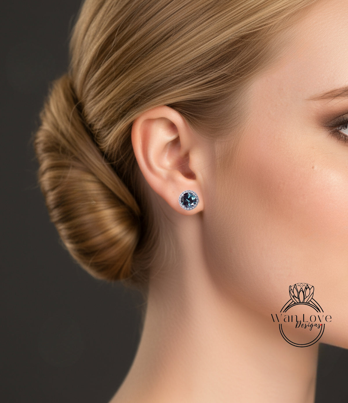 A close-up of a woman's ear with a blue gemstone earring, her hair in a bun, and a logo for "WanLove Designs" visible.