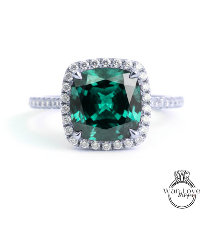 A stunning ring featuring a large, square-cut green gemstone surrounded by a halo of smaller diamonds set in a silver band.